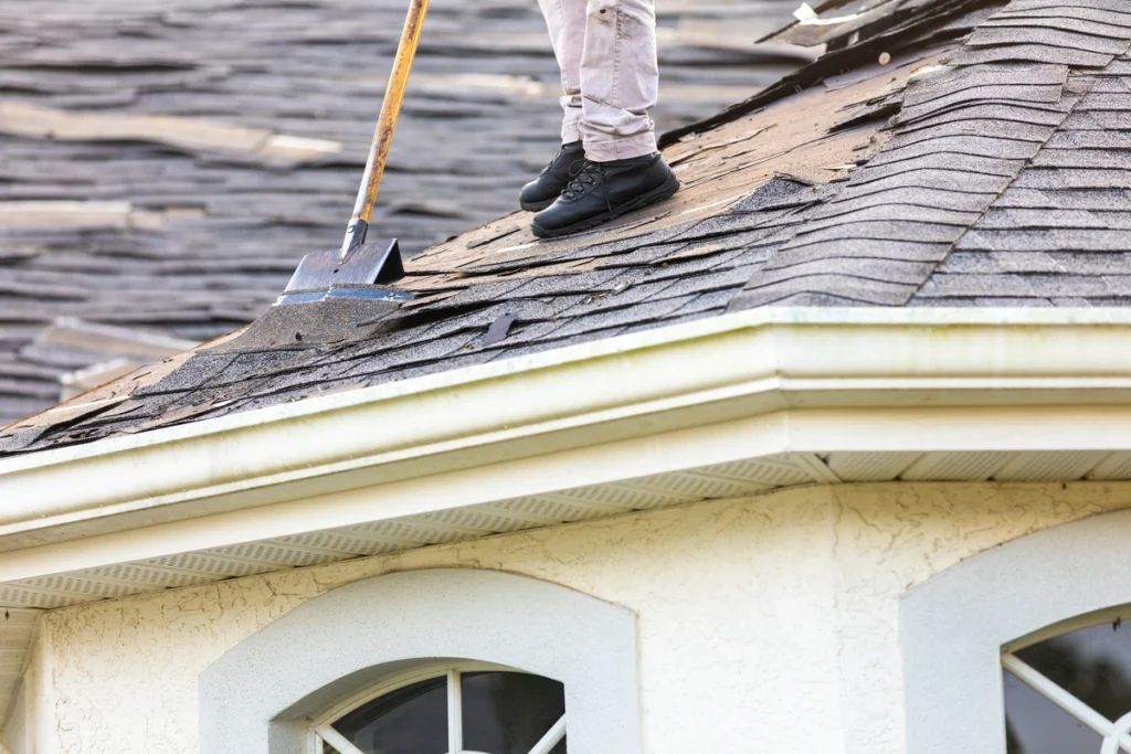 Used - worker removing shingles with shovel