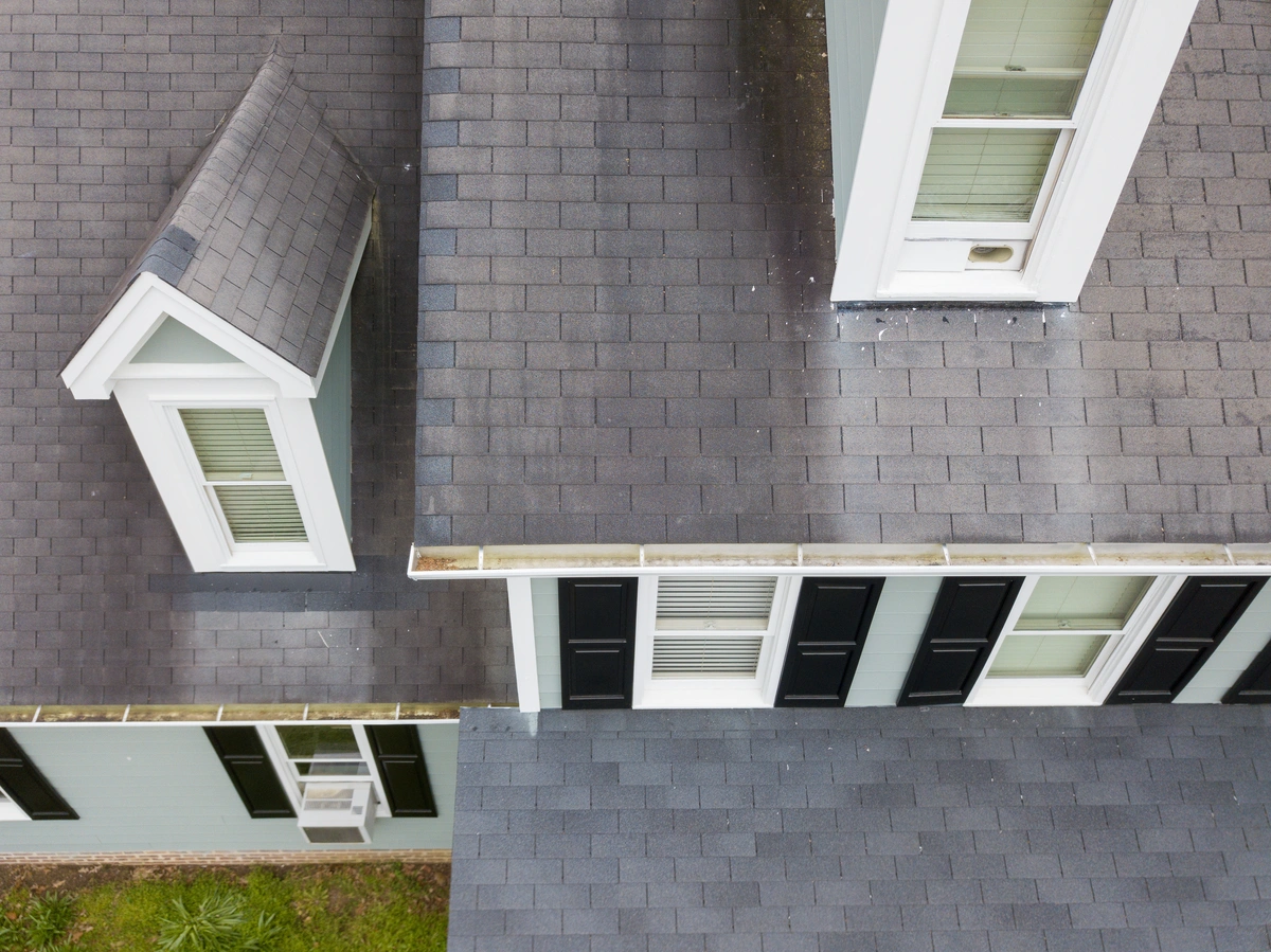 Close-up photo of asphalt shingles on a Wicomico County residential roof showing granule loss, minor surface cracking, and visible weathering from years of Eastern Shore humidity and storm exposure. Taken in natural daylight at rooftop level.