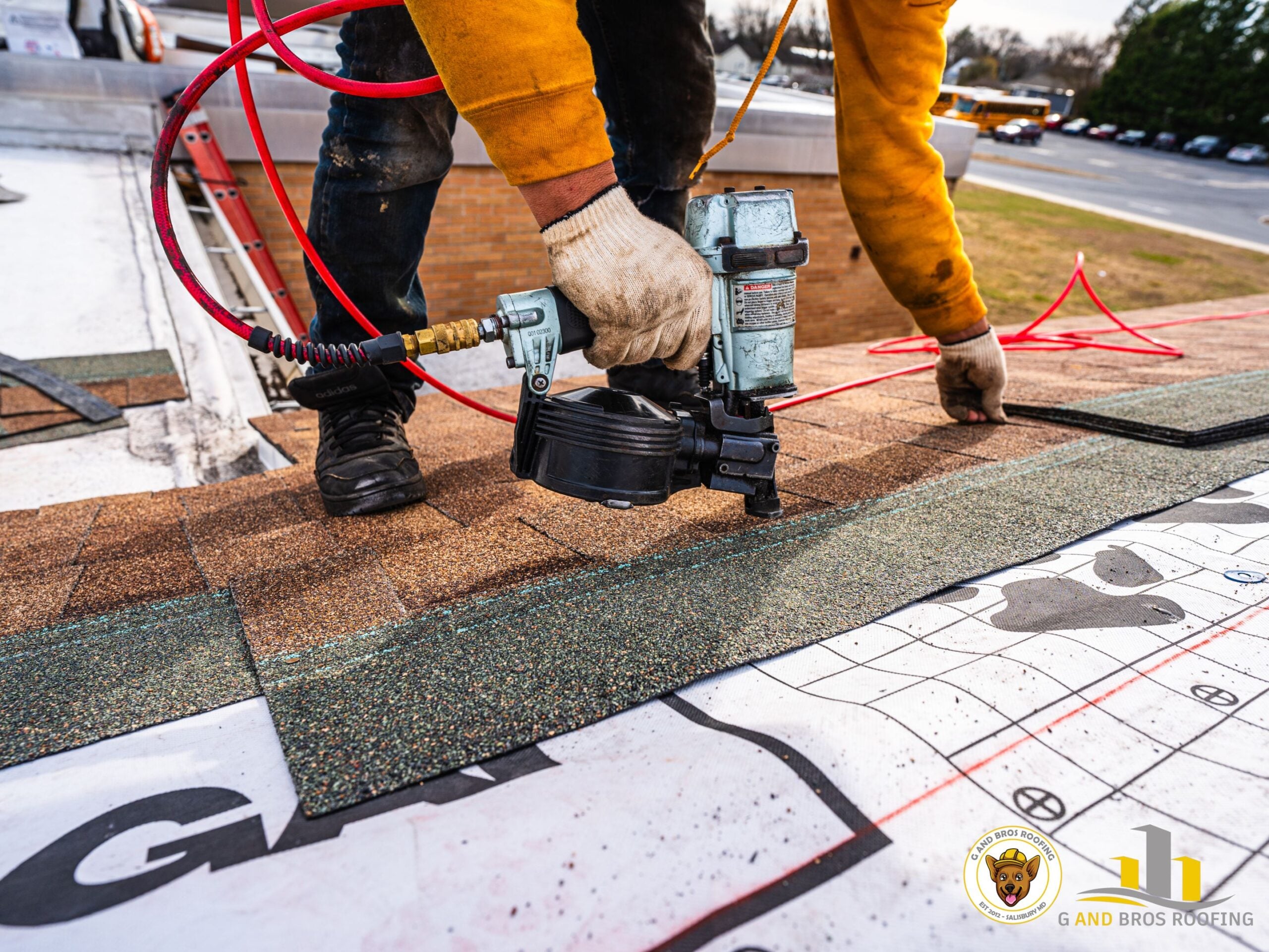 A G and Bros contractor on a Princess Anne-area residential rooftop conducting a pre-replacement inspection, examining shingle surface and chimney flashing. Bright natural daylight, professional candid style, technician in branded shirt or vest.