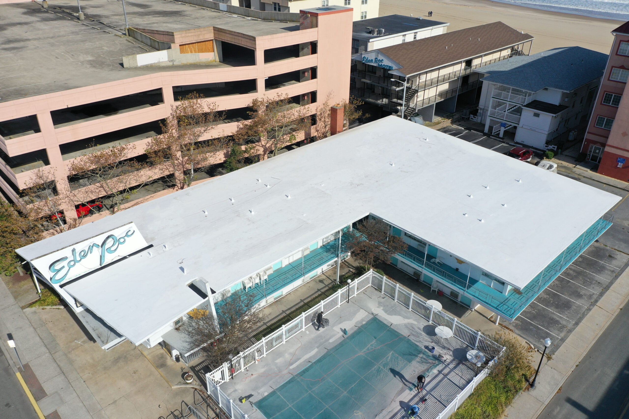 Wide shot of a Delmarva commercial building (restaurant, retail, or condo) in Ocean City with a finished white TPO membrane roof. Real G and Bros job photo preferred.