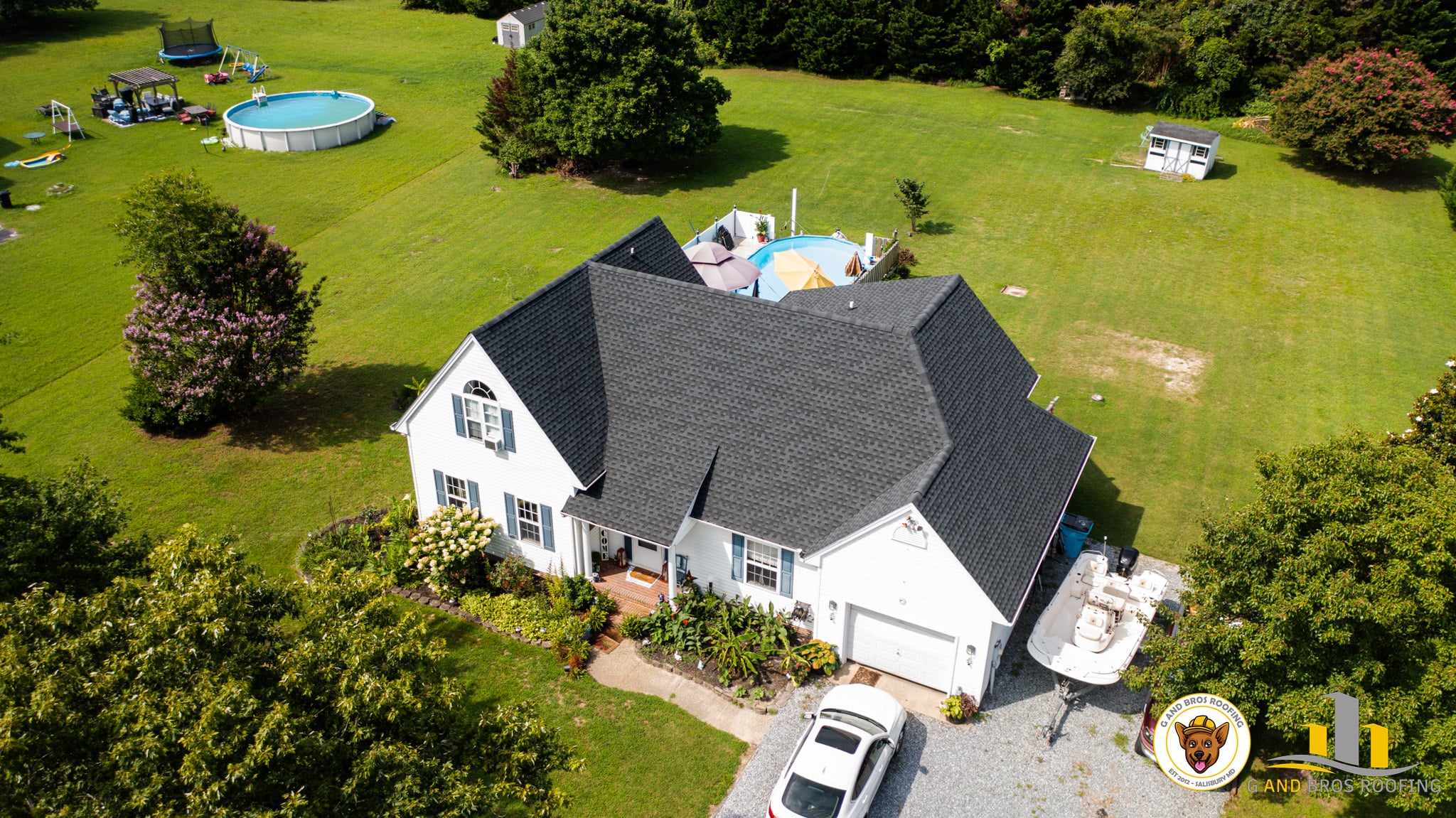 Used - ROB BOSE 26497 Meadow Land Lane Hebron, MD 21830 GAF Timberline HDZ Charcoal Roof Replacement G and Bros Roofing LLC White siding house with black shingle roof. The house in sitting in a lot with green grass and a pool in the back.