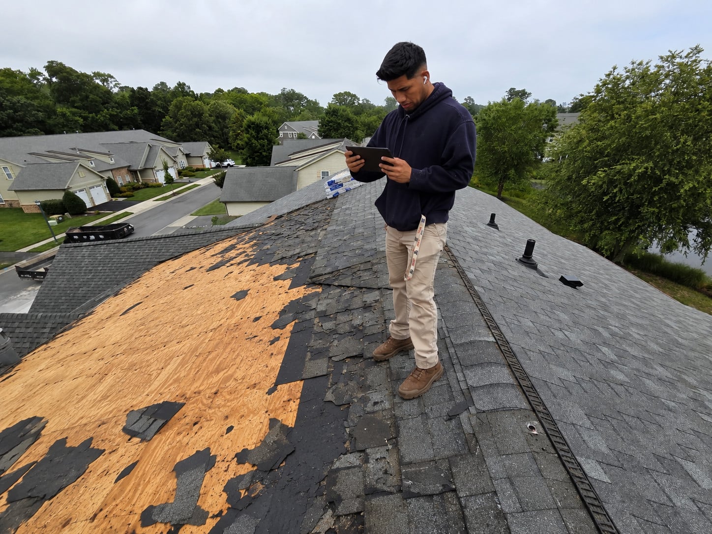 Roofing CRM vs Spreadsheets: How to Tell When You Have Actually Outgrown the Spreadsheet 3 | G and Bros Roofing crew lead documenting exposed decking on a tablet during a tear-off
