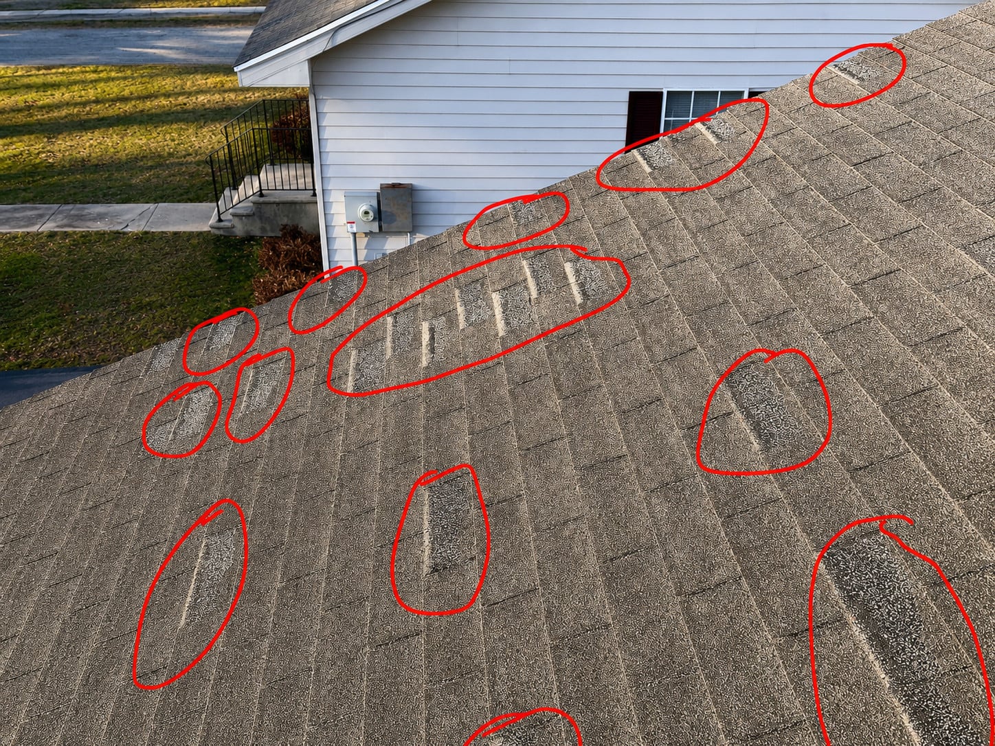 Residential roof inspection in Salisbury MD showing multiple damaged asphalt shingle areas marked for evaluation