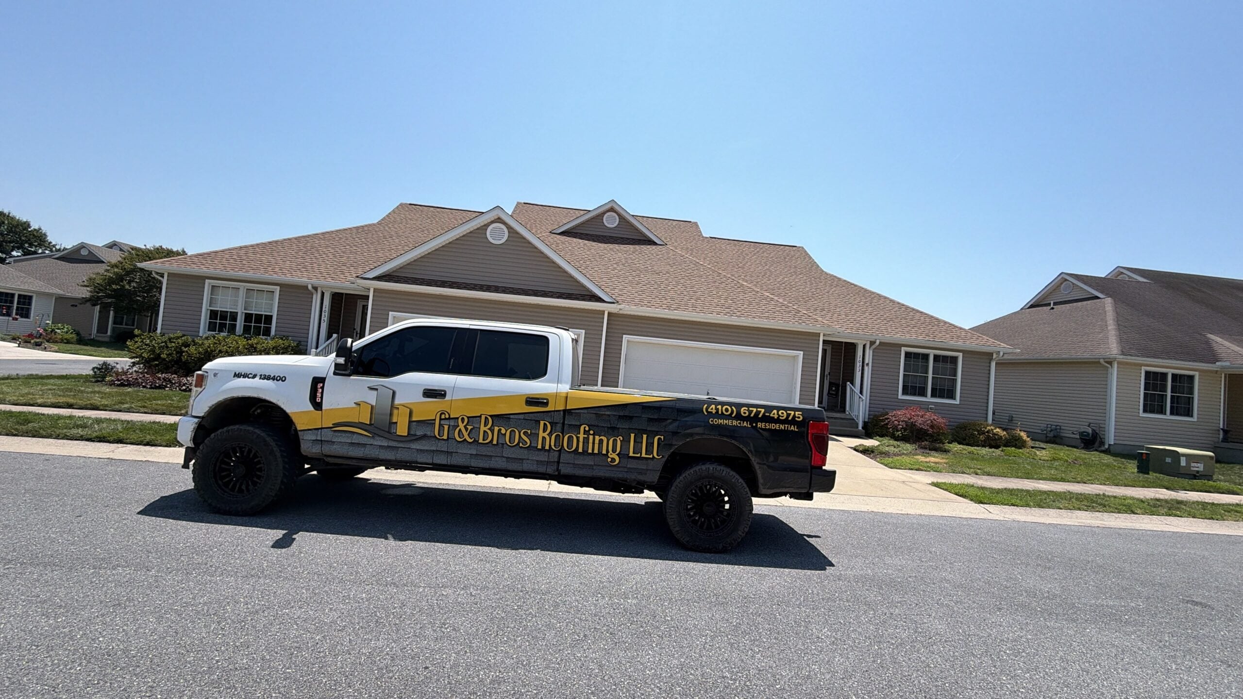 G and Bros branded trucks outside a completed roofing job on the Eastern Shore