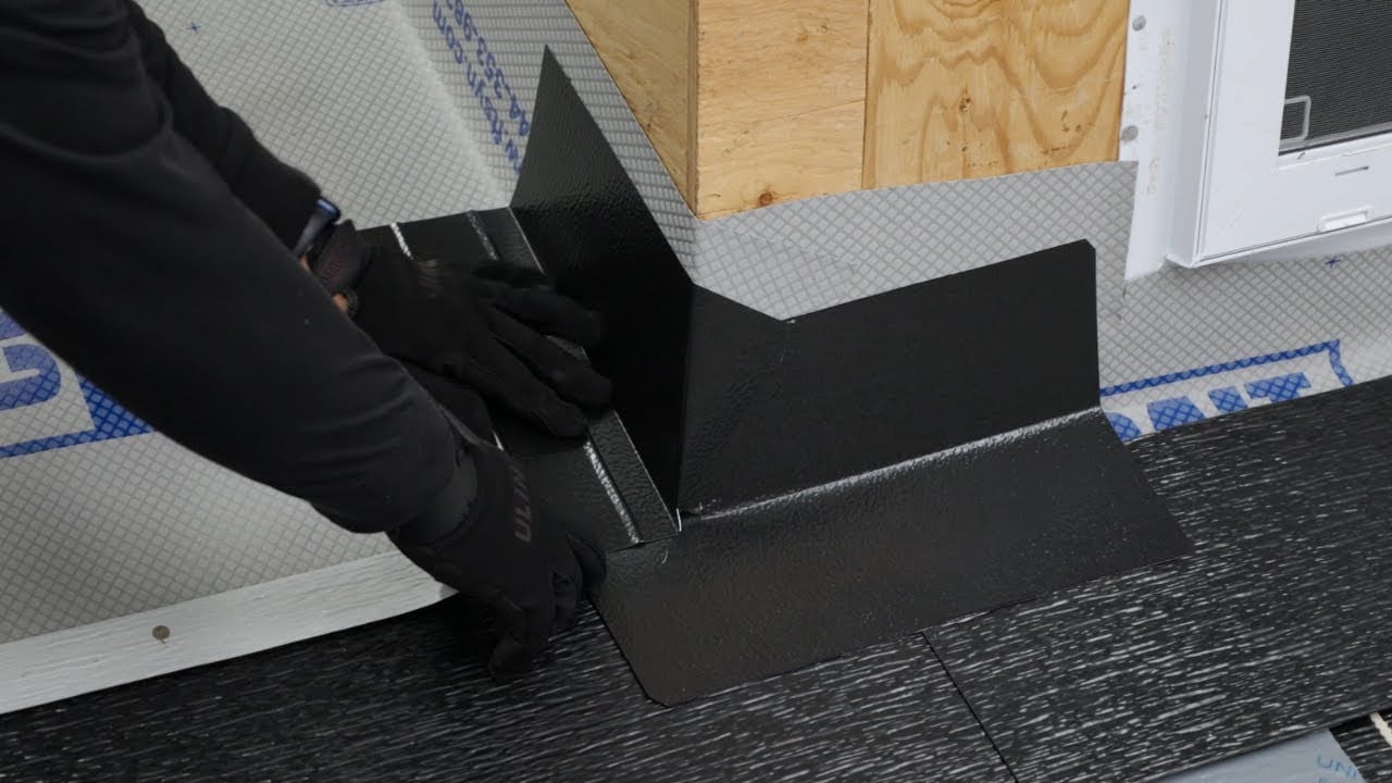 Properly installed step flashing woven into shingle courses where a sloped roof meets a vertical wall